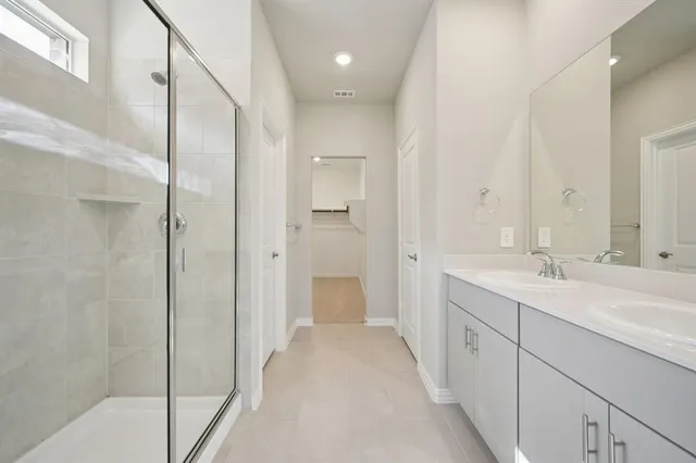 a spacious bathroom with a mirror a shower and vanity