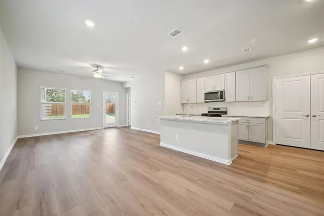 a view of kitchen with granite countertop stainless steel appliances refrigerator sink and cabinets