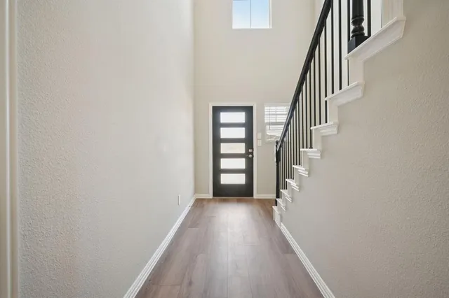 a view of a hallway with wooden floor and staircase