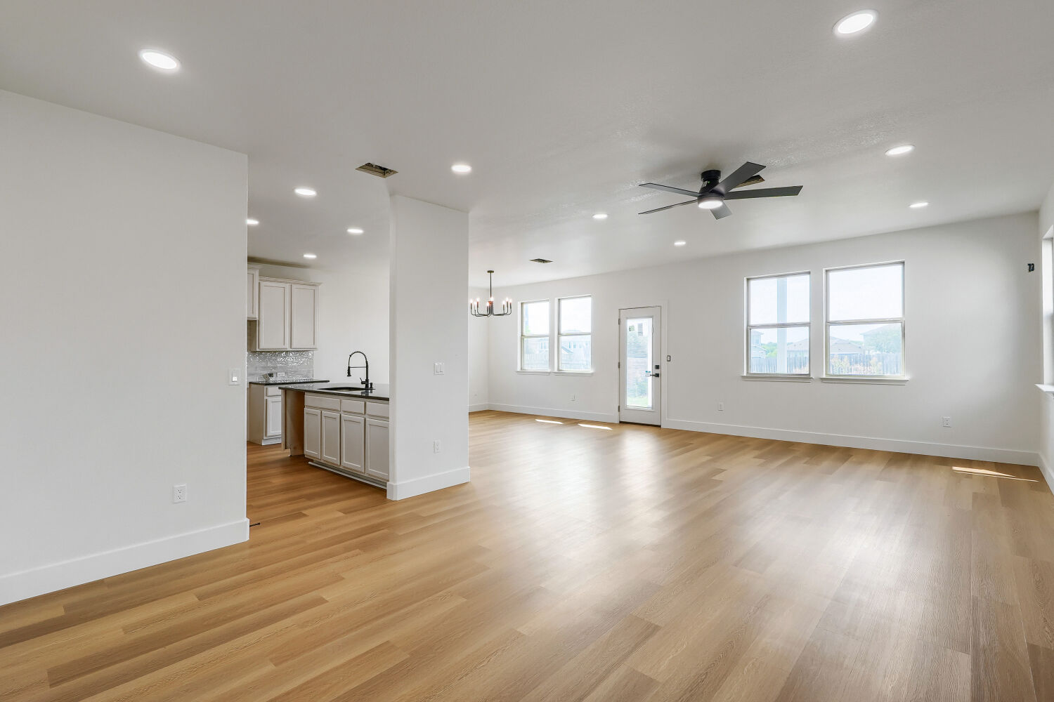 320 Triumph Road Buda, TX 78610 - Photo 3 of 22 Smooth wood floors flow throughout this airy, open-concept living area and kitchen space.