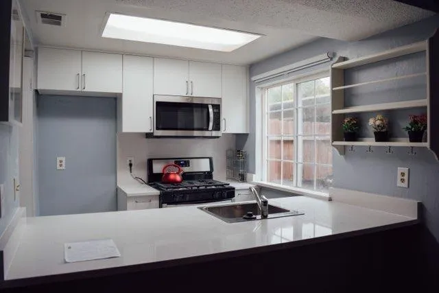 a kitchen with kitchen island a sink appliances and cabinets