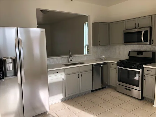 a kitchen with a sink and steel appliances