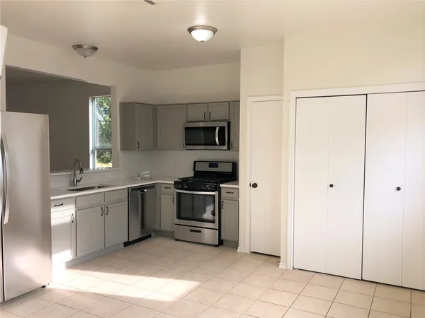 a kitchen with stainless steel appliances granite countertop a refrigerator and a stove top oven