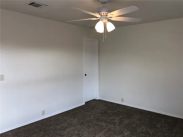 an empty room with a chandelier fan