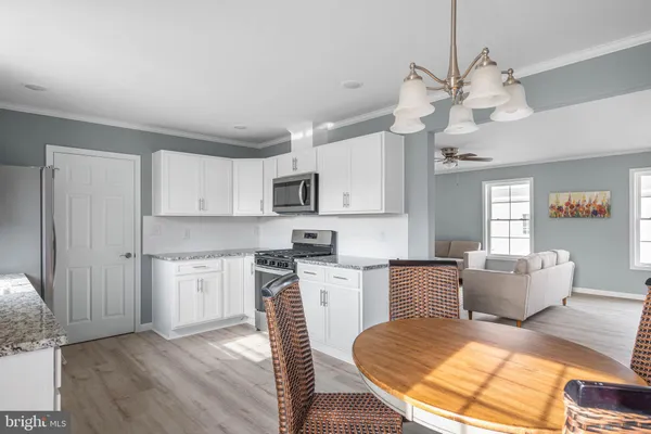a large kitchen with cabinets wooden floor and stainless steel appliances