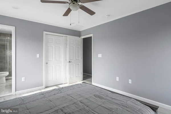 an empty room with chandelier fan and windows