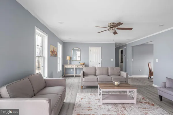 a living room with furniture ceiling fan and a window