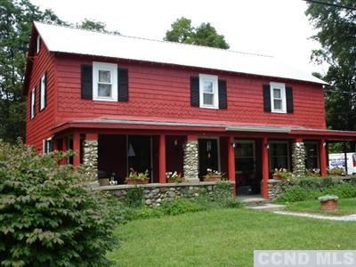 a view of brick house with a yard potted plants and a table