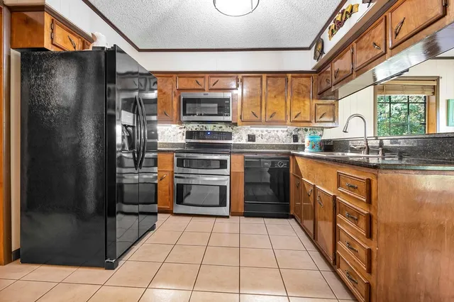 a kitchen with stainless steel appliances granite countertop a refrigerator and a sink