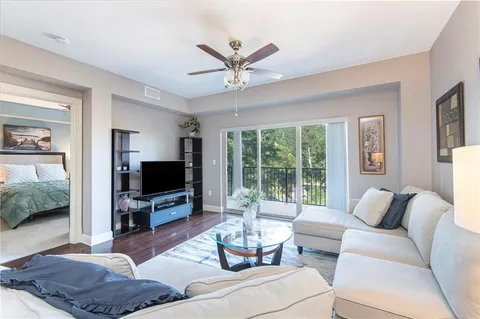 a living room with furniture a flat screen tv and a large window