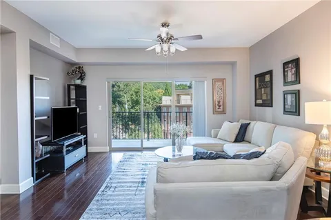 a living room with furniture a flat screen tv and a floor to ceiling window
