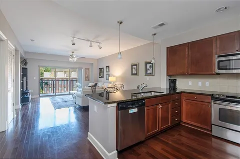 a kitchen with stainless steel appliances granite countertop a sink stove and wooden floor