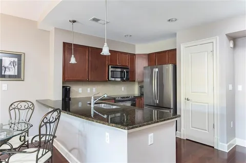 a kitchen with stainless steel appliances granite countertop a sink refrigerator and cabinets