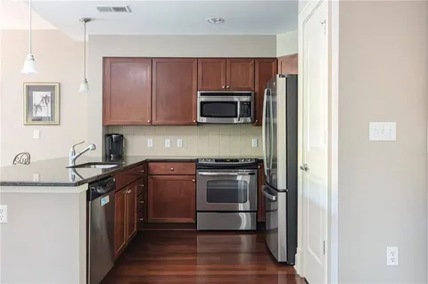 a kitchen with stainless steel appliances wooden cabinets and a stove top oven