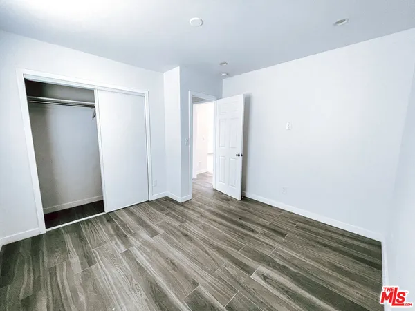 a view of an empty room with closet and a window