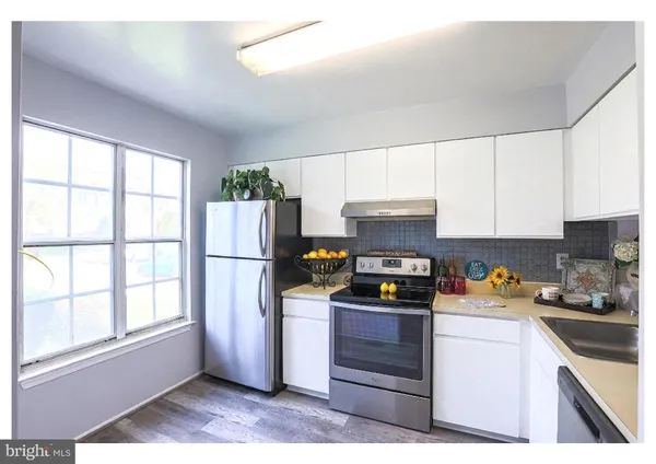 a kitchen with stainless steel appliances a refrigerator sink and microwave
