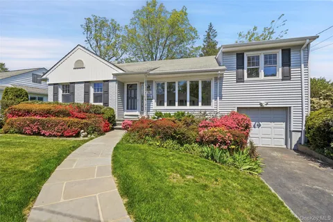 a front view of a house with a yard and potted plants