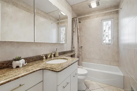 a bathroom with a granite countertop sink a toilet and bathtub