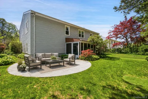 a view of a house with backyard and sitting area