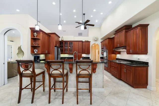 a living room with furniture kitchen view and a chandelier