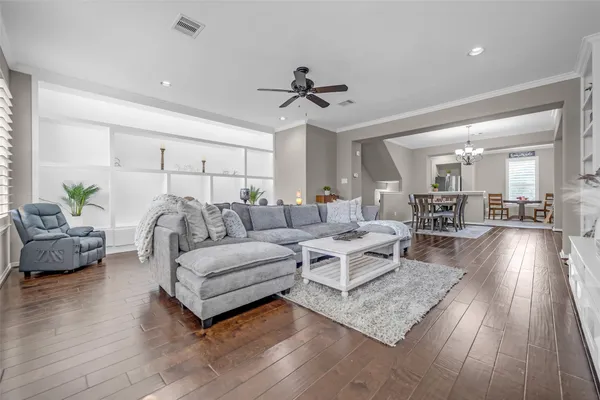 a living room with furniture and a view of kitchen