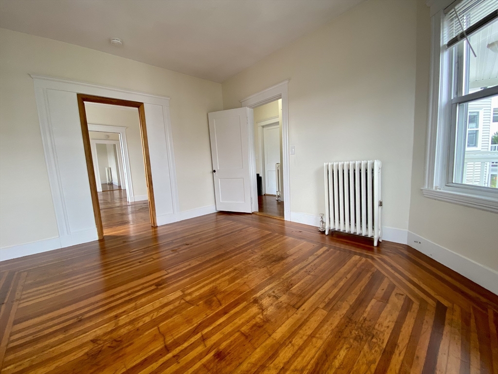 14 Belknap Street, Unit 3 Somerville, MA 02144 - Photo 12 of 25 a view of a room with wooden floor and windows