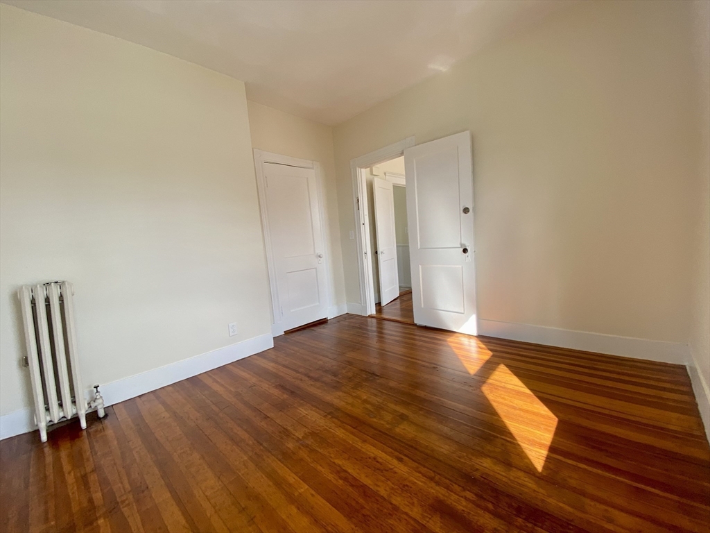14 Belknap Street, Unit 3 Somerville, MA 02144 - Photo 17 of 25 a view of empty room with wooden floor and fan