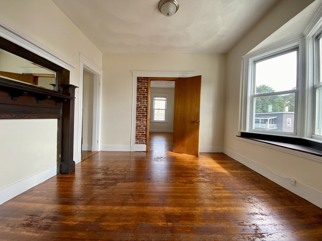 14 Belknap Street, Unit 3 Somerville, MA 02144 - Photo 20 of 25 a view of an empty room with wooden floor and a window