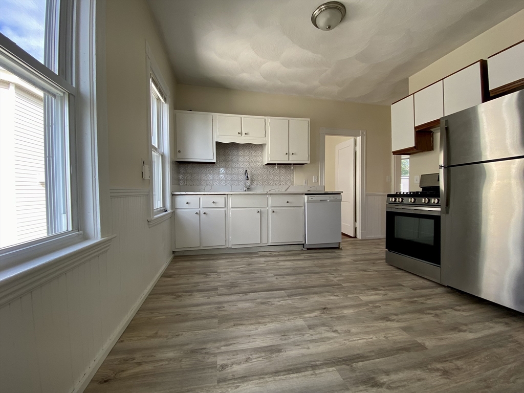 14 Belknap Street, Unit 3 Somerville, MA 02144 - Photo 8 of 25 a kitchen with stainless steel appliances granite countertop a refrigerator sink and stove