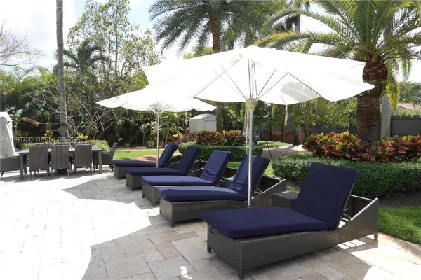 a view of a backyard with swimming pool and sitting area