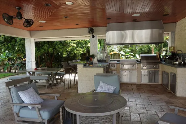 a living room with patio furniture and a floor to ceiling window