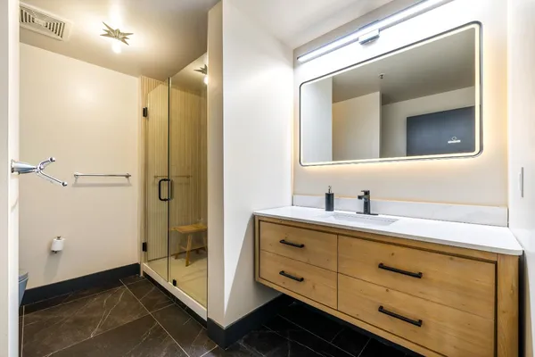 a bathroom with a shower sink and mirror