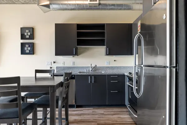 a kitchen with stainless steel appliances granite countertop a sink and a refrigerator