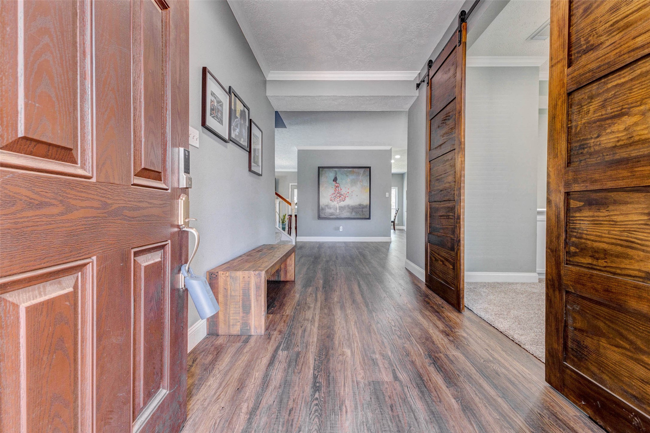 9215 Landry Boulevard Spring, TX 77379 - Photo 4 of 42 Step inside and discover a warm, inviting interior featuring neutral paint tones, crown molding, Rose Canyon Pine Luxury Waterproof vinyl flooring throughout the downstairs, and thoughtfully updated finishes that create a timeless and welcoming first impression.