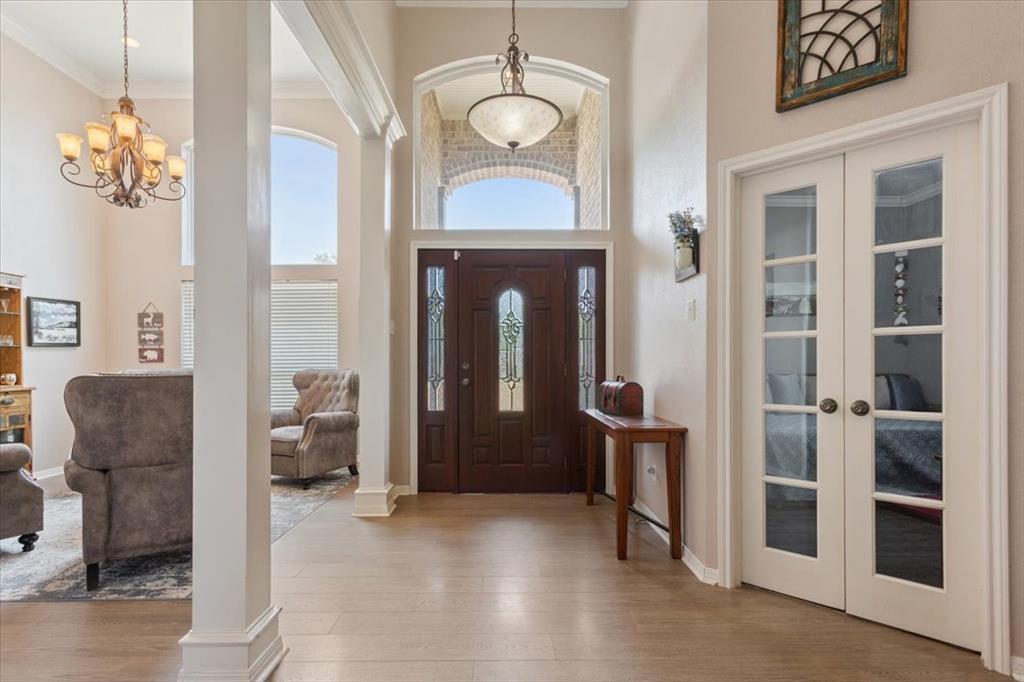 111 Spring Creek Street Waco, TX 76705 - Photo 6 of 40 Wood-finish flooring, white paneled French doors, vaulted ceiling, decorative chandelier, and an ornate front door with leaded glass