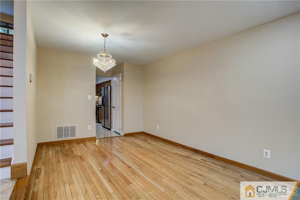 901 Timber Oaks Road Edison, NJ 08820 - Photo 13 of 27 a view of a room with wooden floor and chandelier