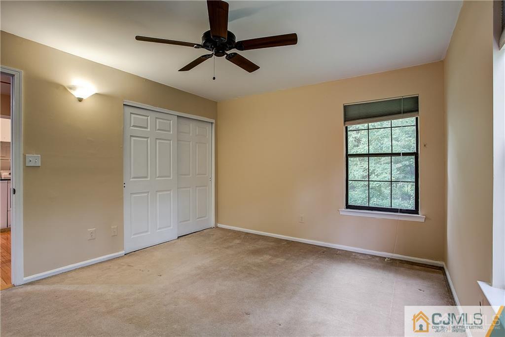 901 Timber Oaks Road Edison, NJ 08820 - Photo 23 of 27 en empty room with windows and ceiling fan
