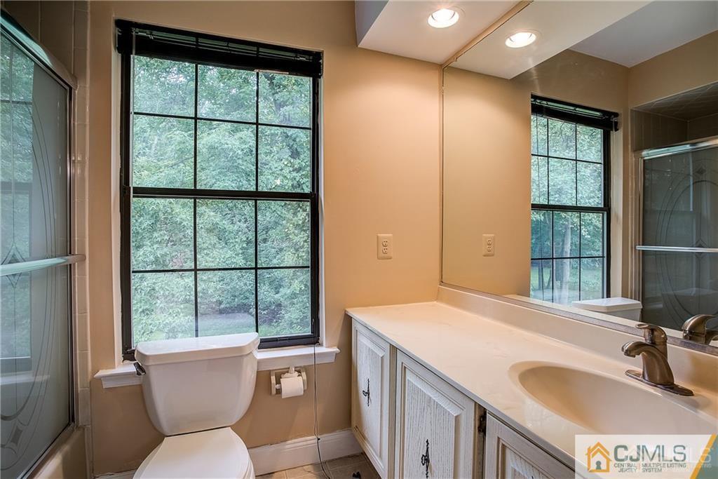 901 Timber Oaks Road Edison, NJ 08820 - Photo 24 of 27 a bathroom with a sink and a large mirror