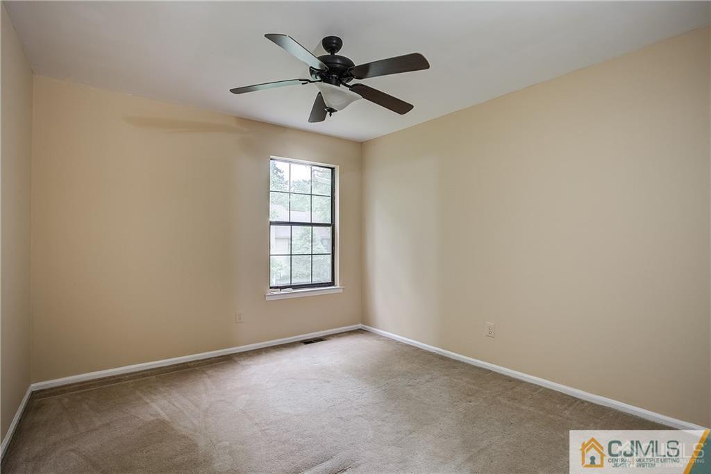 901 Timber Oaks Road Edison, NJ 08820 - Photo 25 of 27 an empty room with a window and a fan