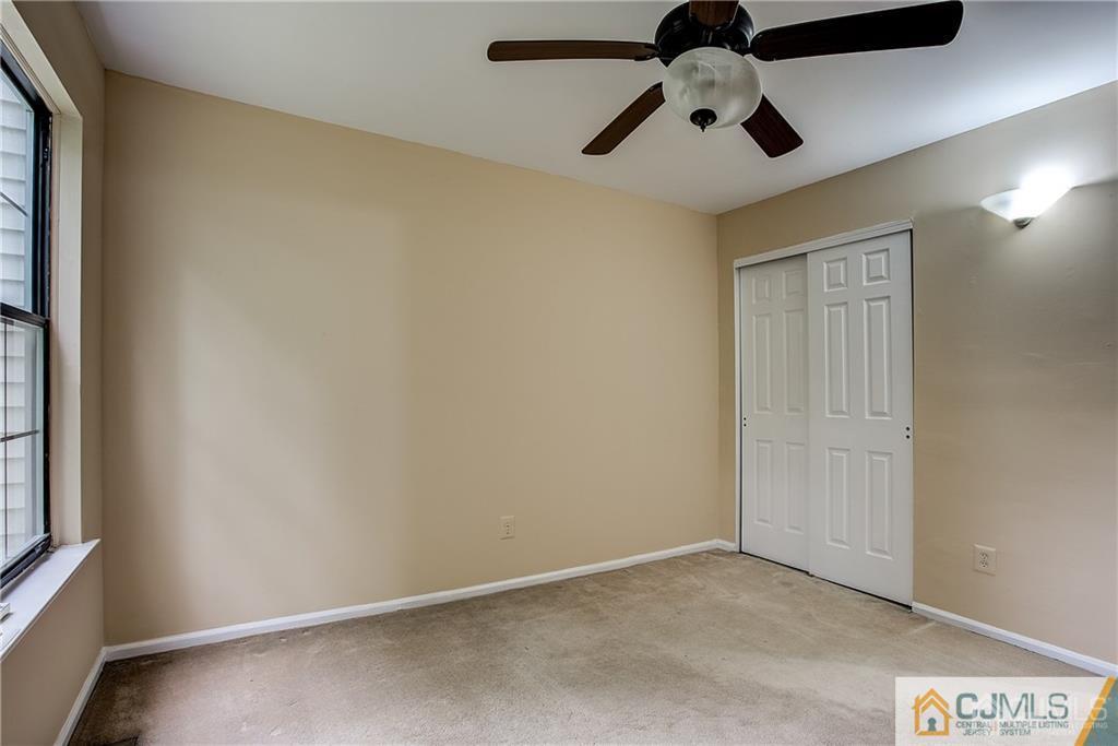 901 Timber Oaks Road Edison, NJ 08820 - Photo 26 of 27 an empty room with a ceiling fan and window
