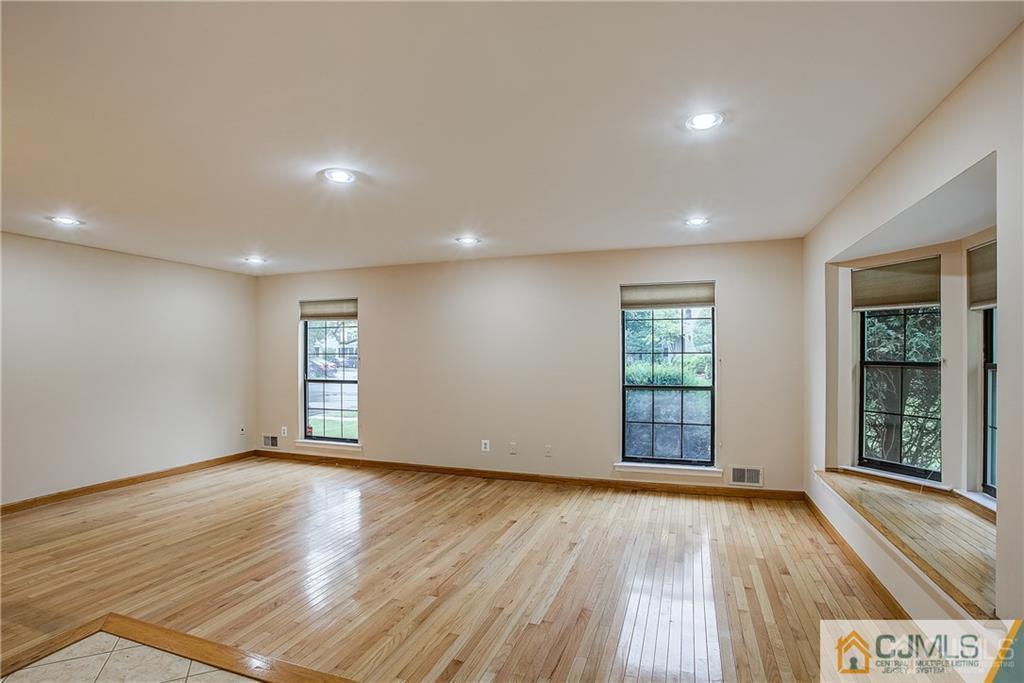 901 Timber Oaks Road Edison, NJ 08820 - Photo 4 of 27 a view of an empty room with wooden floor and a window