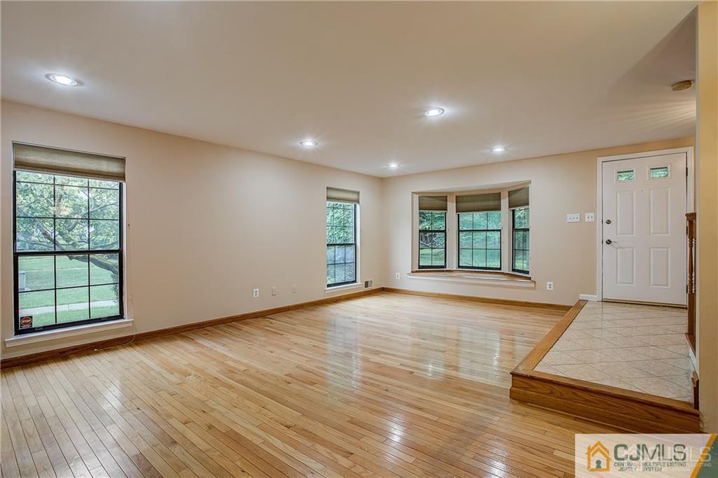 901 Timber Oaks Road Edison, NJ 08820 - Photo 5 of 27 an empty room with wooden floor and windows