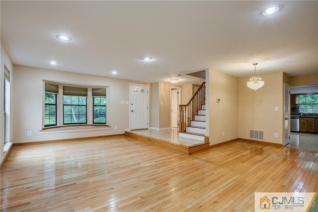901 Timber Oaks Road Edison, NJ 08820 - Photo 6 of 27 a view of an empty room with wooden floor and stairs
