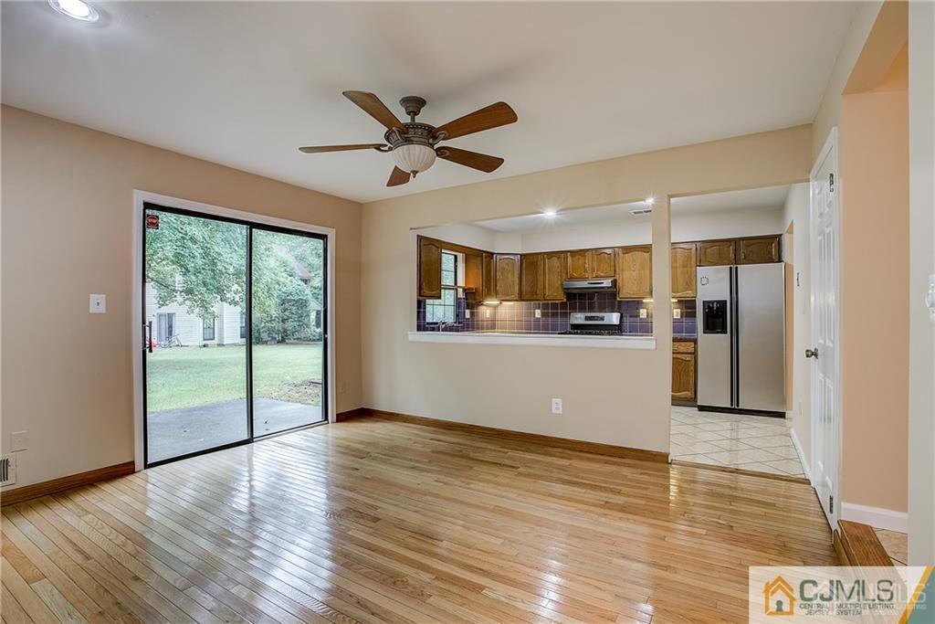 901 Timber Oaks Road Edison, NJ 08820 - Photo 9 of 27 a view of a kitchen with wooden floor and a ceiling fan