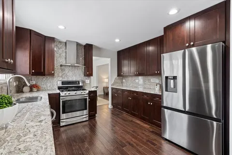 a kitchen with stainless steel appliances granite countertop a refrigerator stove and sink