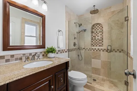 a bathroom with a granite countertop sink toilet and shower