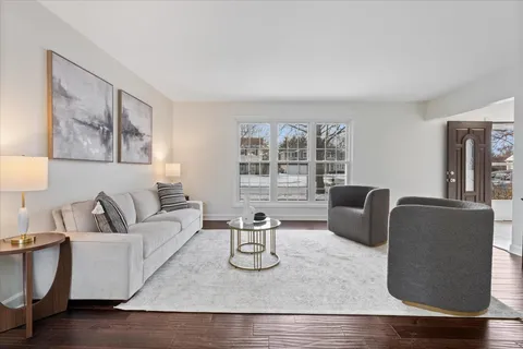 a living room with furniture a desk and chair with wooden floor