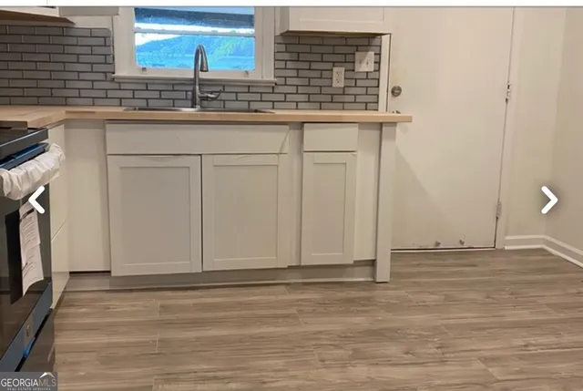 a view of kitchen with granite countertop cabinets and sink