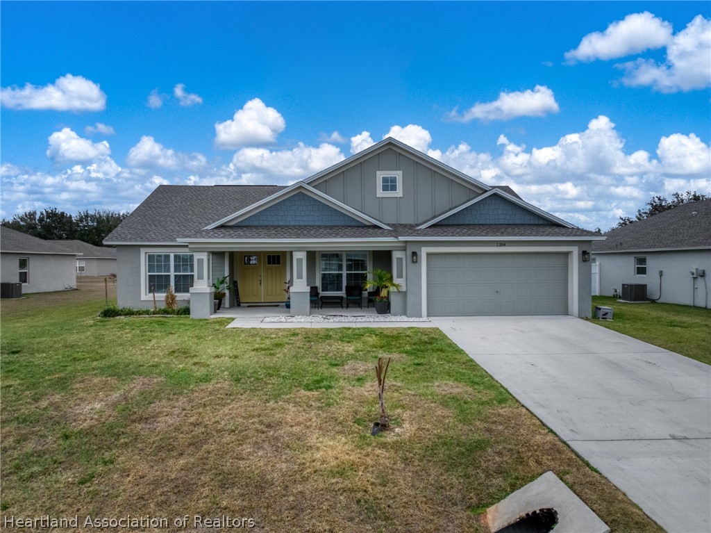 1204 Ridge Drive Avon Park, FL 33825 - Photo 1 of 20 a front view of a house with a garden and patio