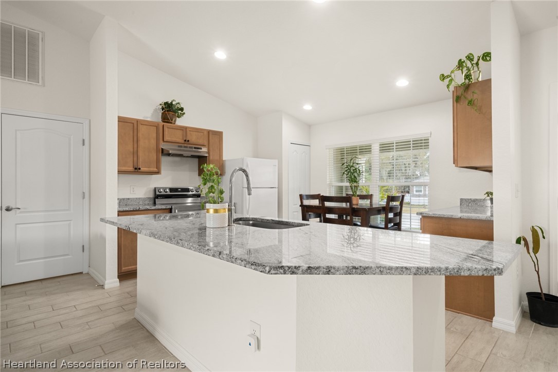 1204 Ridge Drive Avon Park, FL 33825 - Photo 4 of 20 a large kitchen with granite countertop a sink a counter top space and cabinets